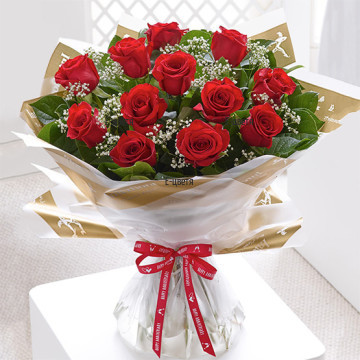Класически, стилен, пищен и романтичен букет от червени рози - 15 стръка, обилно аранжирани с разнообразни, свежи зеленини.