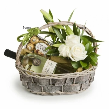 Стилна кошница с цветя и подаръци, подходящи за хора с вкус и стил. Аранжировка от цветя, аранжирани на пиафлора - рози и лилиуми.