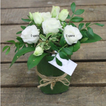 Нежна аранжировка от бели рози и зеленина, аранжирана на пиафлора. Направете своята поръчка бързо и лесно в нашия онлайн магазин за цветя и подаръци
