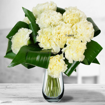 Classic bouquet of  11 white carnations, arranged with a lot of fresh, exotic greenery.