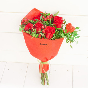 Романтичен букет от червени рози, обилна зеленина и декорация, подходящ за романтична годишнина или изненада.