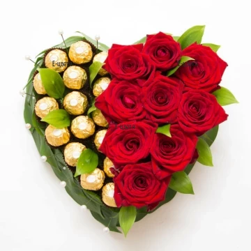 Романтична аранжировка във формата на сърце, с аранжирани върху нея червени рози и луксозни шоколадови бонбони Ferrero Rocher.