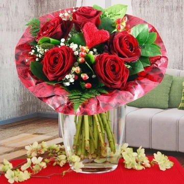 Romantic and passoinate bouquet of red roses, abundant greenery and impressive wrapping.
