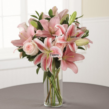 Tender combination of lilies and roses ind soft pink hues, wrapped in a lot of greenery.