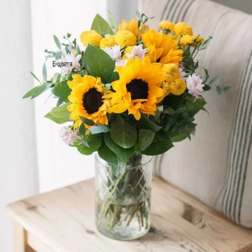 Gorgeous, summer bouquet of fresh greenery, bright sunflowers and tender chrysanthemums.