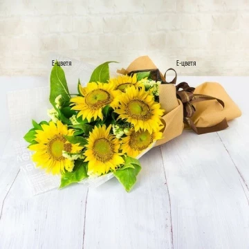 Adorable, beautiful, cheerful bouquet of sunflowers, fresh greenery and fancy papers