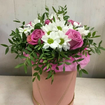 A beautiful and delicate arrangement of various flowers and greens. A combination of pink roses and white chrysanthemums.