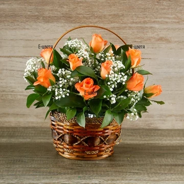 Очарователна, китна кошница от слънчеви оранжеви рози, нежна пелена от бяла гипсофила и обилна зеленина.