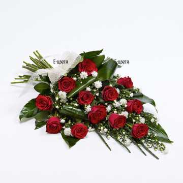 Голям букет от червени рози, обилна зеленина и цветчета на хризантема за завършен вид.