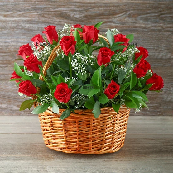 A basket with 21 red roses and greenery.