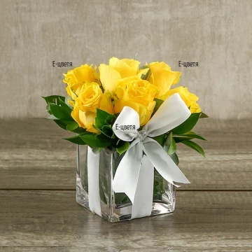 Send an arrangement with roses and greenery in glass cube.