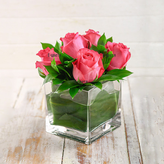 An online order and a delivery of roses in glass cube