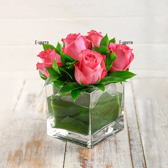 An online order and a delivery of roses in glass cube