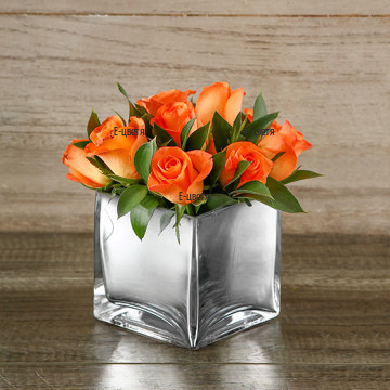 Send nice arrangement with roses in glass cube.
