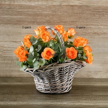 Modern arrangement in a basket - orange roses and greenery. Perfect gift for a Birthday, for a Name day, for any anniversary or special day.