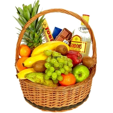 A basket, arranged with various fresh fruits - pineapple, bananas, apples, oranges, kiwi, avocado, grapes and gifts.