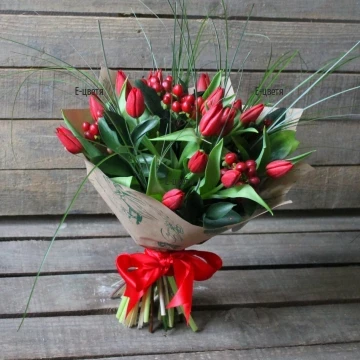 A beautiful, romantic, passionate bouquet of fresh spring tulips, generously arranged with fresh greeneries and red chypericum.