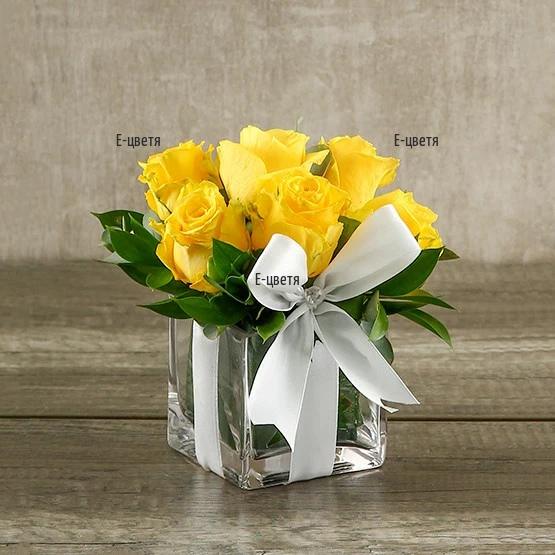 Send an arrangement with roses and greenery in glass cube.
