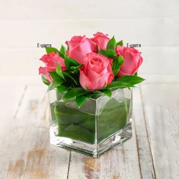 An online order and a delivery of roses in glass cube